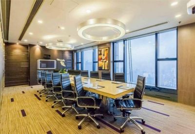 Spacious boardroom with a long table, modern black chairs, and circular pendant lighting.