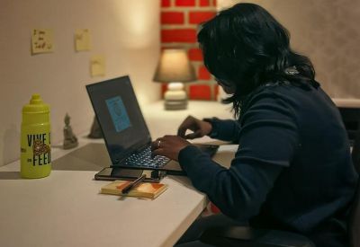 Workspace with a laptop, yellow bottle, and ambient lighting.