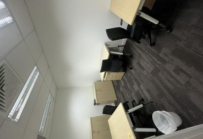 Private office suite with three wooden desks and ergonomic black chairs.