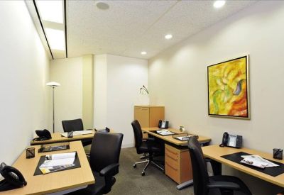 Private office suite with two wooden desks, black ergonomic chairs, and colorful abstract wall art.