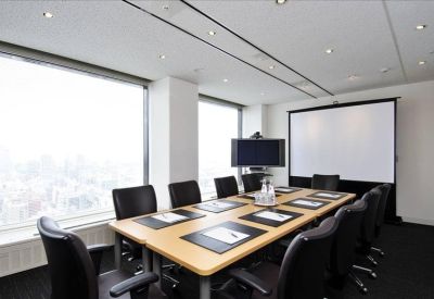 Modern conference room with a large screen, whiteboard, and city views through large windows.