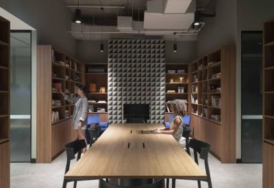 Long timber conference table in a modern library-style meeting room.