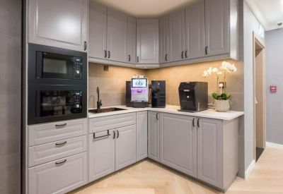 Modern corner pantry with grey cabinetry and integrated appliances.