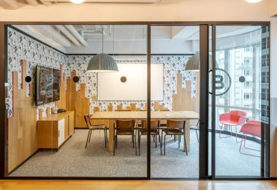 Professional glass-enclosed meeting room with a large wooden table and artistic wallpaper.