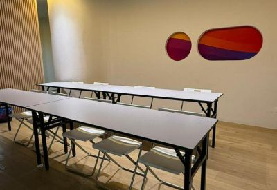 Training room setup with long tables and abstract wall art.