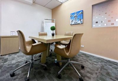 Modern office kitchen and breakout area with wooden cabinetry and a white breakfast bar.