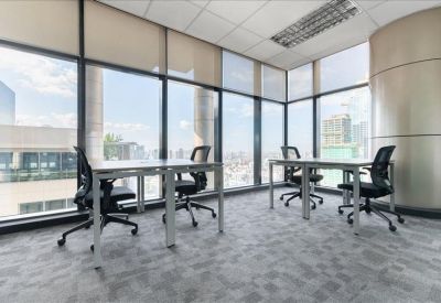 Bright corner office with floor-to-ceiling windows and two modern desks.