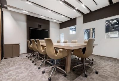 Contemporary boardroom with tan leather chairs and a large wooden table.