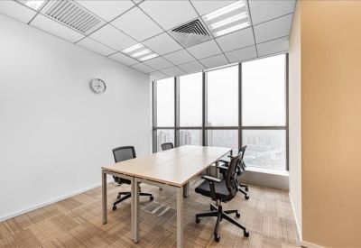 Modern meeting room with a light-wood conference table and six black mesh chairs.