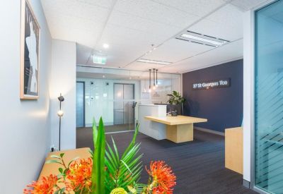 Professional reception area with a wooden desk, navy feature wall, and floral arrangement.