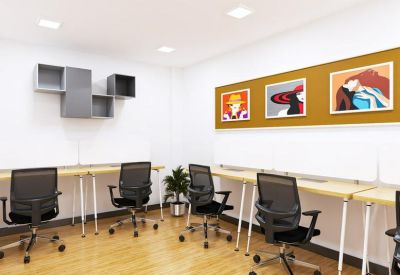 Modern workspace featuring light wood desks, black ergonomic chairs, and colorful wall art.