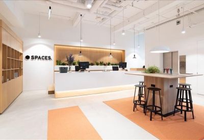Modern reception area featuring a white desk, wood paneling, and brand signage.