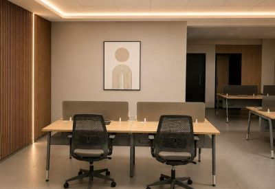Modern open-plan office featuring wooden desks and frosted privacy dividers.