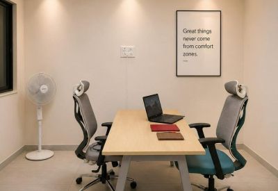 Private two-person office suite with a wood-top desk, ergonomic chairs, and a desktop computer.