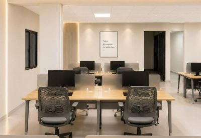 Clean coworking area with rows of workstations and minimalist wall art.