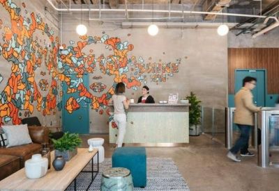 Reception area featuring a large colorful mural and a modern white front desk.