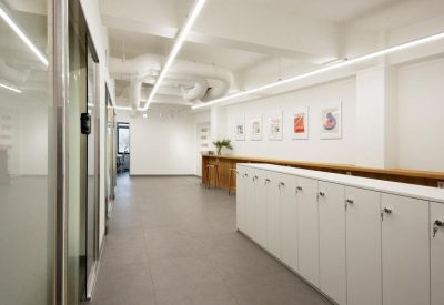 Hallway view showing a row of white storage lockers and desk areas.