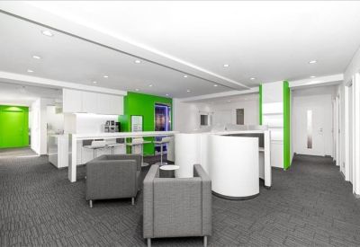 Spacious communal lounge with grey armchairs and vibrant green accent walls.
