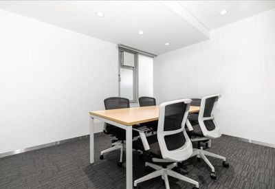 Modern four-person meeting room with white and black mesh chairs and light wood table.
