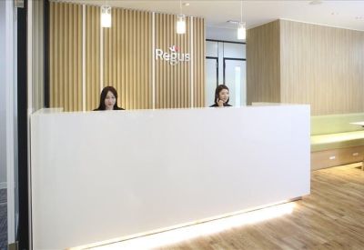 Bright reception desk with wood paneling and friendly staff.
