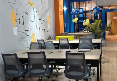 Bright office space featuring vibrant wall art, indoor plants, and blue accent furniture.