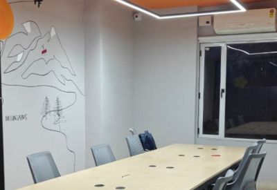 Meeting room with a large wooden table and a minimalist mountain wall mural.