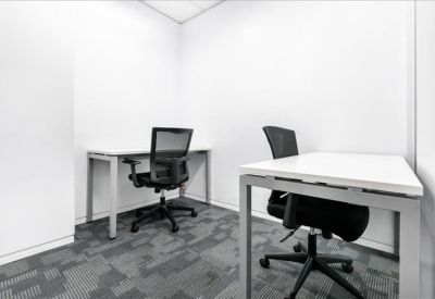 Small private office with two white desks and ergonomic black mesh chairs.