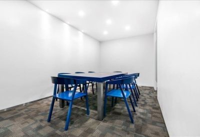 Meeting room with a dark blue table surrounded by matching blue chairs.