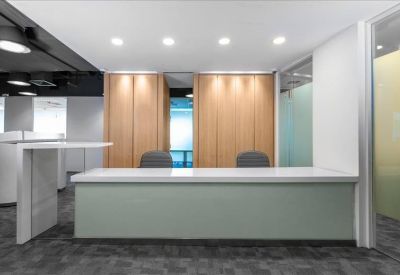 Minimalist reception area with a long white desk and wood-paneled feature wall.