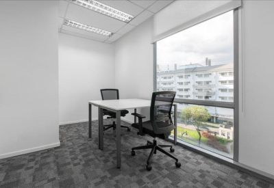 Two-person private office suite with large windows and grey patterned carpet.