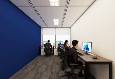 Spacious communal coworking area with a long wooden desk and a bold blue feature wall.