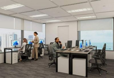 Open-plan office space with multiple workstations and large windows overlooking the city.