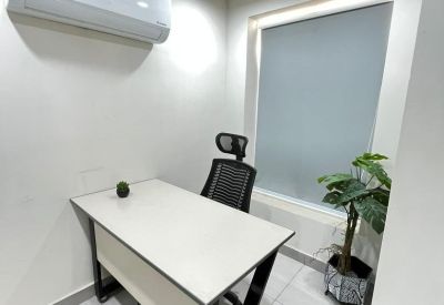 Private office suite with a white desk, task chair, and large window with a roller blind.