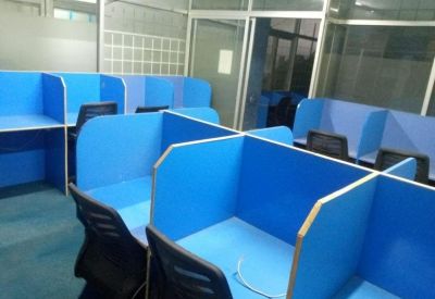 Blue and white open-plan workstations with black mesh chairs.