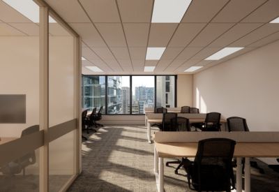 Modern open-plan workspace with white desks and large windows.