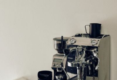 Professional espresso machine and coffee grinder on a black counter.