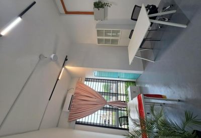 Bright office space featuring a white desk, potted plants, and a window with striped blinds.