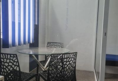Meeting area at 43, KRG Nagar Main Street with a glass-topped table and black patterned chairs.