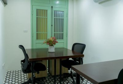 Private meeting room with a wooden table, ergonomic chairs, and patterned tile flooring.
