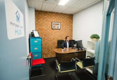 Individual workspace with a brick accent wall and blue filing cabinet.