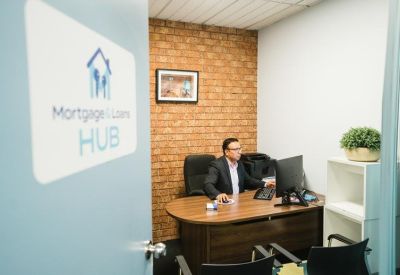 A modern private office seen through a doorway with a mortgage broker signage.