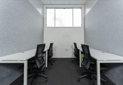 Private office pod with four desks and grey acoustic wall panels.