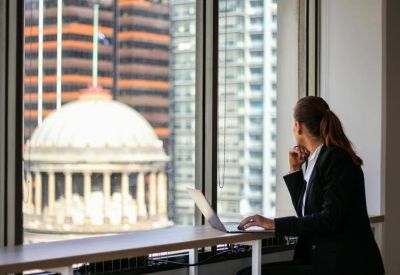 Business professional working on a laptop overlooking a domed building.