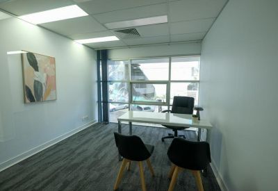 Corner office with two chairs and large windows offering natural light.