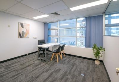 Meeting room with a whiteboard and large windows for natural lighting.