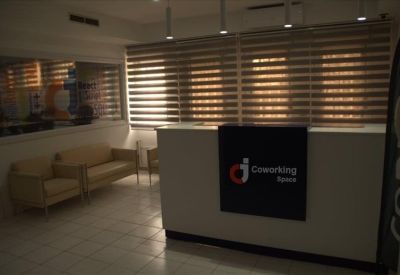 Spacious two-person office with desks facing a panoramic window view of the city skyline.