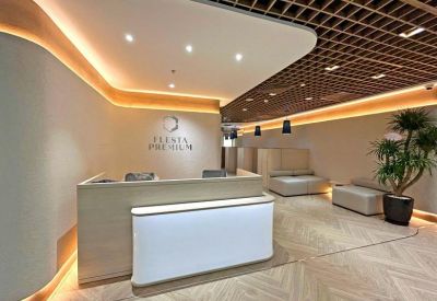 Reception area with a light wood desk, glowing white front panel, and warm accent lighting.