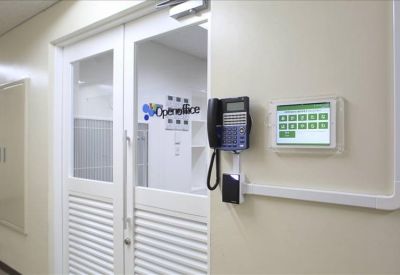 Secure office entrance with a digital keypad and phone system on a white wall.