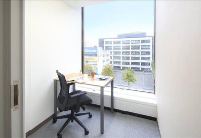 Private office with a large window and views of city buildings.