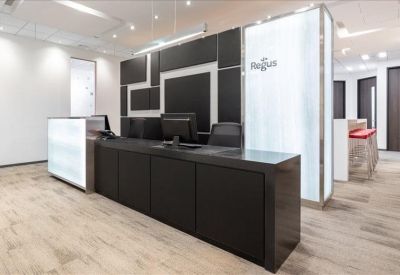 Professional reception area with a black desk and illuminated frosted glass pillars.